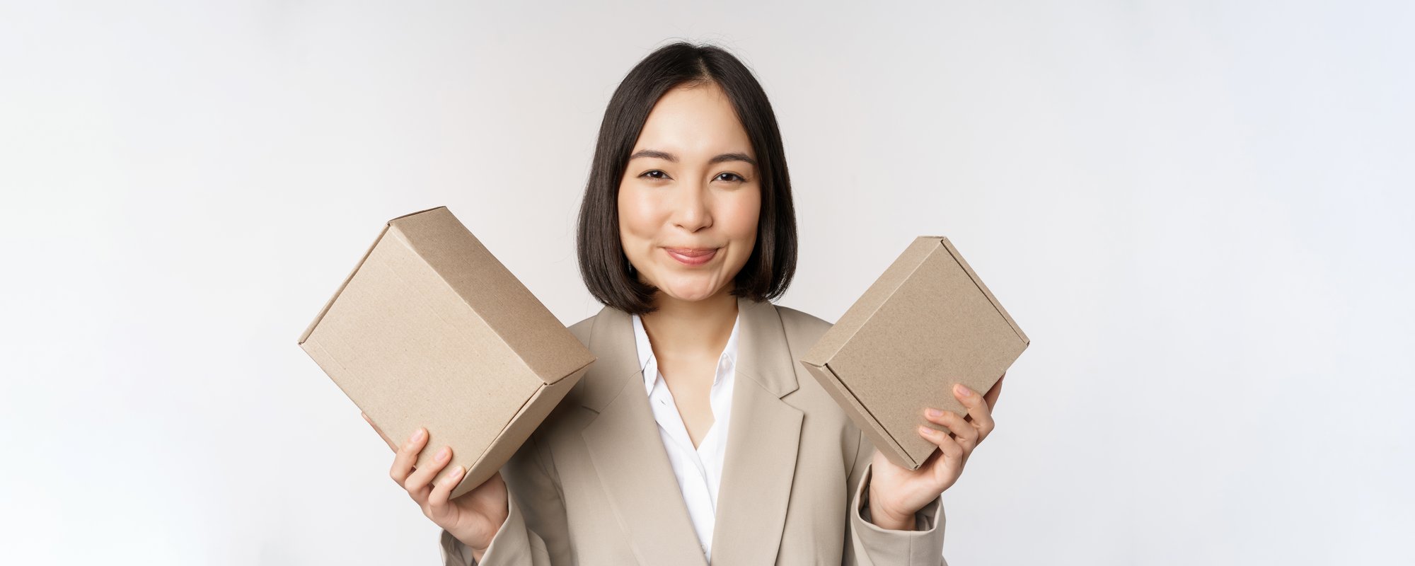 image-saleswoman-asian-businesswoman-holding-boxes-with-company-brand-product-smiling-camera-standing-against-white-background image-saleswoman-asian-businesswoman-holding-boxes-with-company-brand-product-smiling-camera-standing-against-white-background